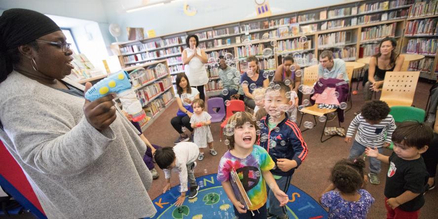 Oakland Public Library Storytime — Engaging group activity Energetic preschoolers in a library enjoy bubbles and storytelling during an interactive group session.